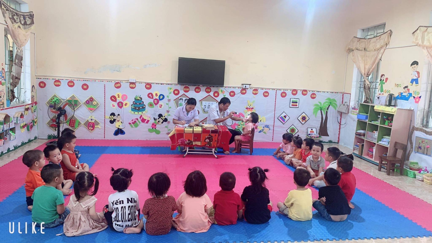 Các con ngồi rất ngoan và vui vẻ khi được các bác sỹ khám sức khỏe cho mình